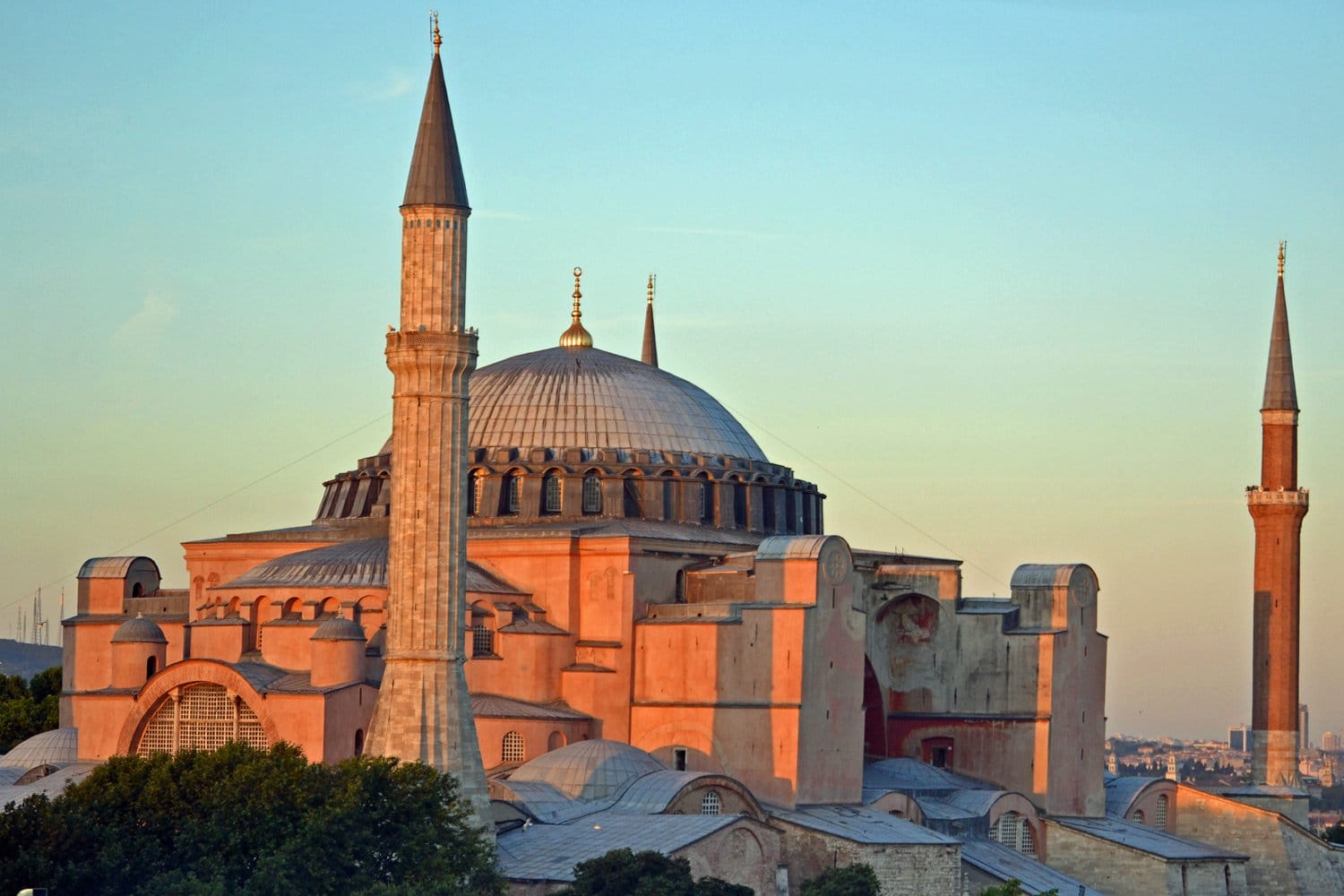 Hagia Sophia exterior at sunset, showcasing domes and minarets against a clear sky in Istanbul, Turkey.