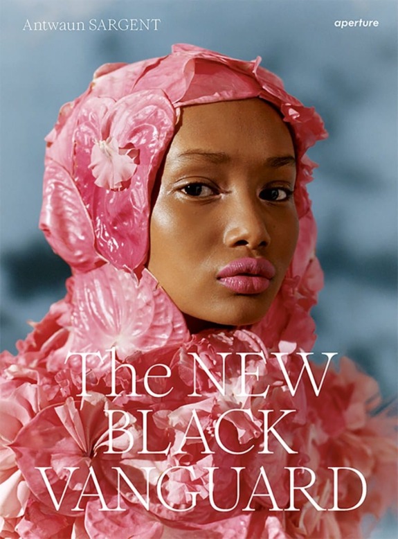 Cover of "The New Black Vanguard" featuring a model in a pink floral outfit against a blurred blue background.