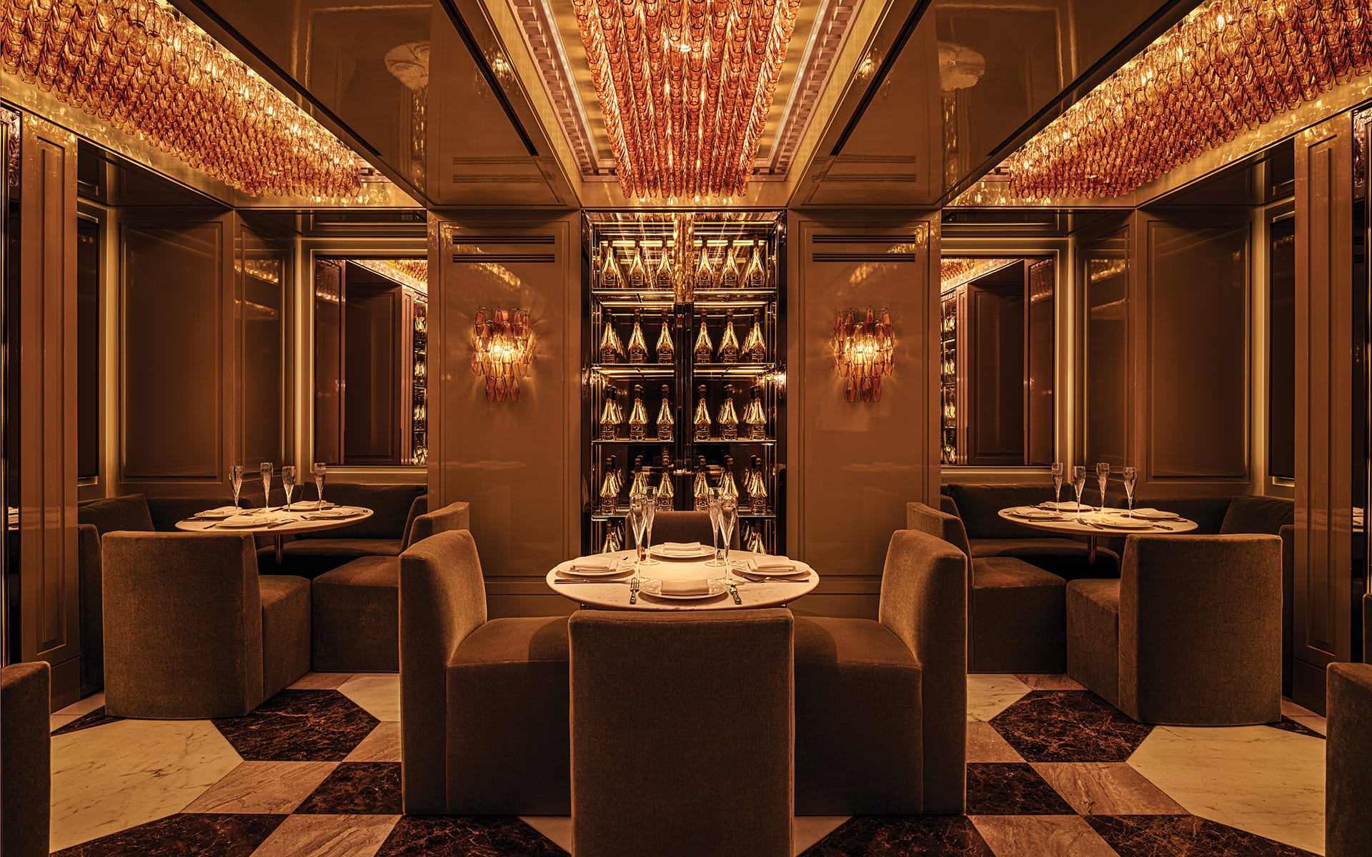 Luxurious restaurant interior with elegant lighting, plush seating, and a mirror wall reflecting a warm, inviting ambiance.