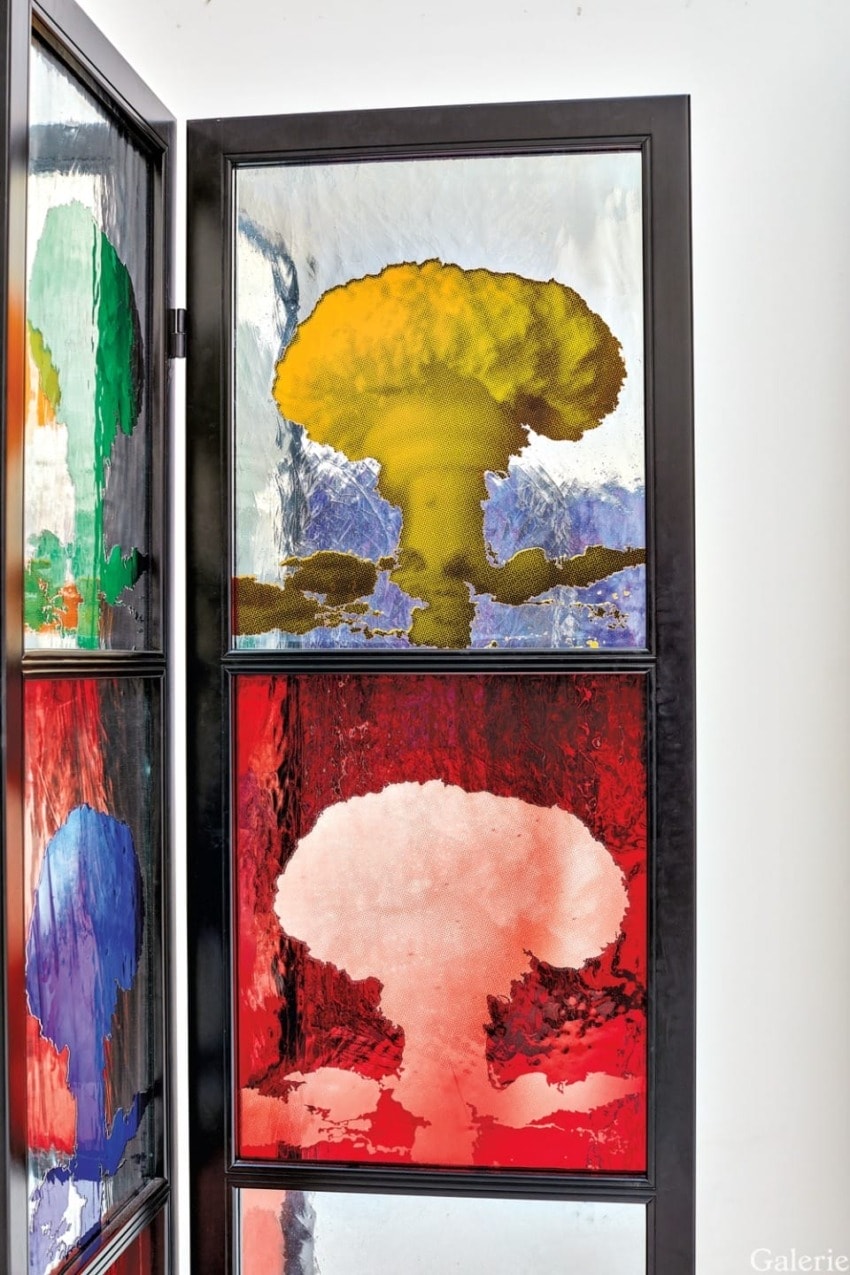 Colorful abstract art on a multi-paneled window with vibrant orange, yellow, green, and red hues in a modern interior.