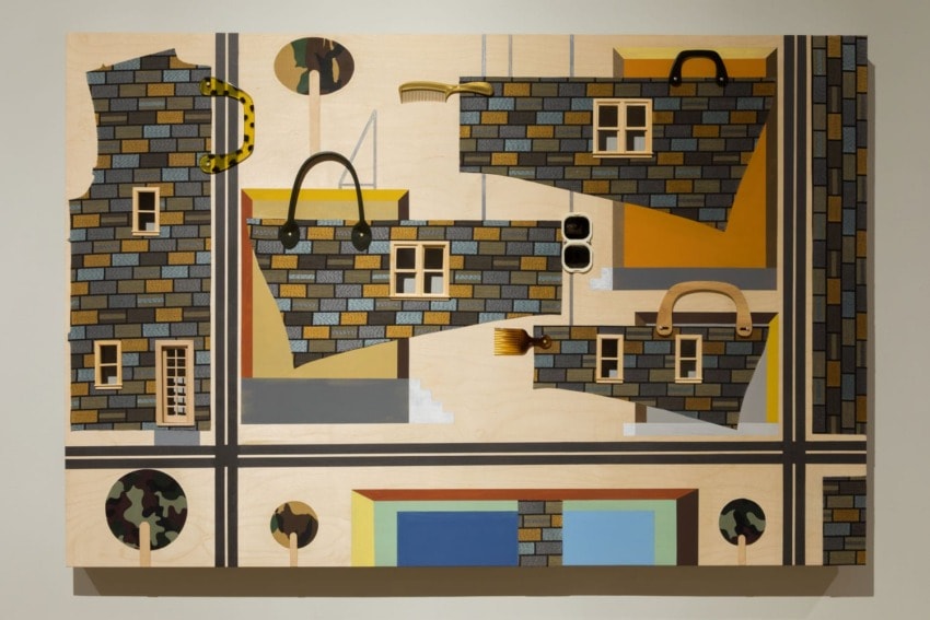 Abstract artwork featuring geometric shapes and patterns resembling buildings and urban elements on a wooden canvas.