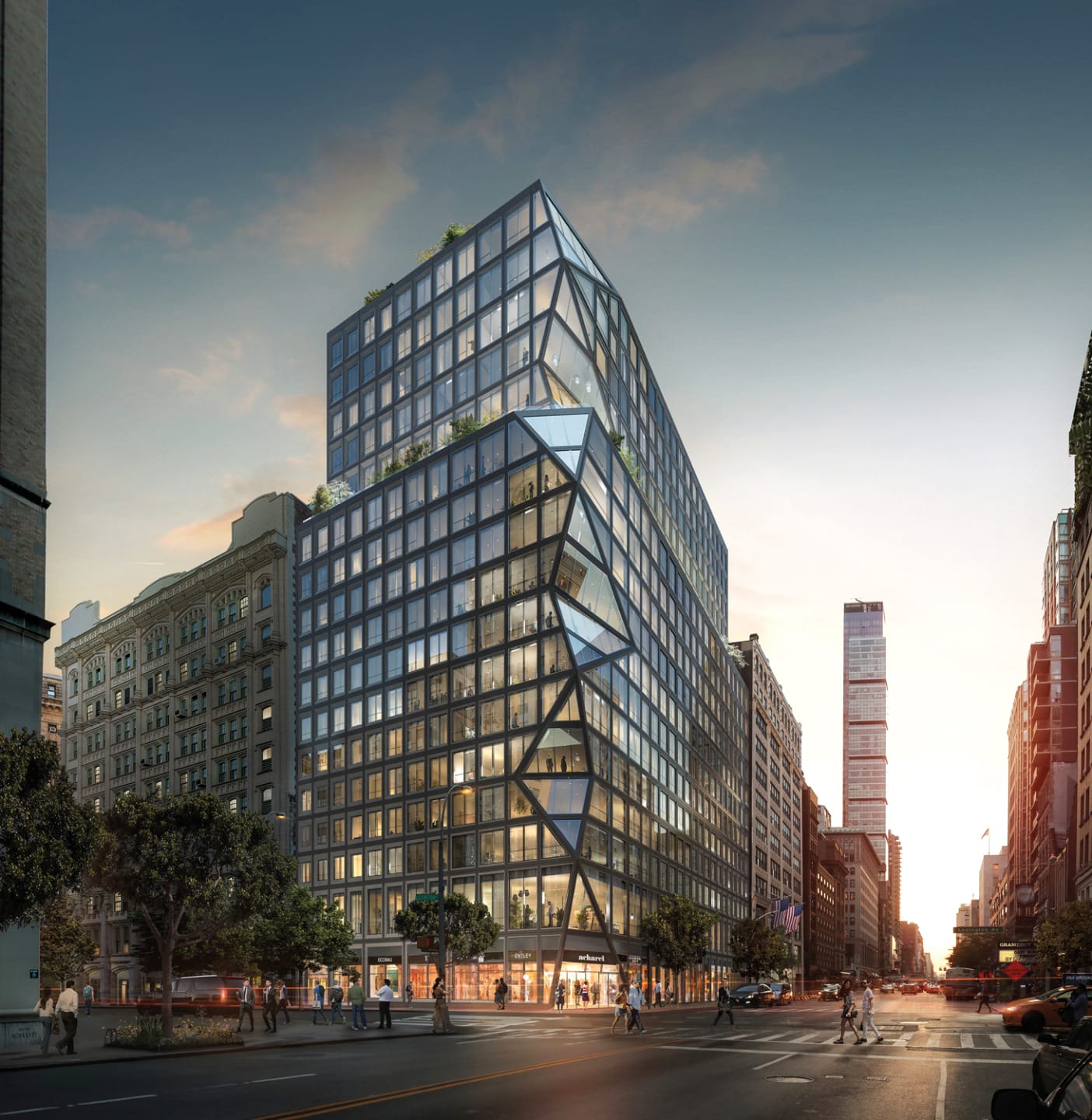 Modern glass office building with unique geometric design on a busy city street at sunset.
