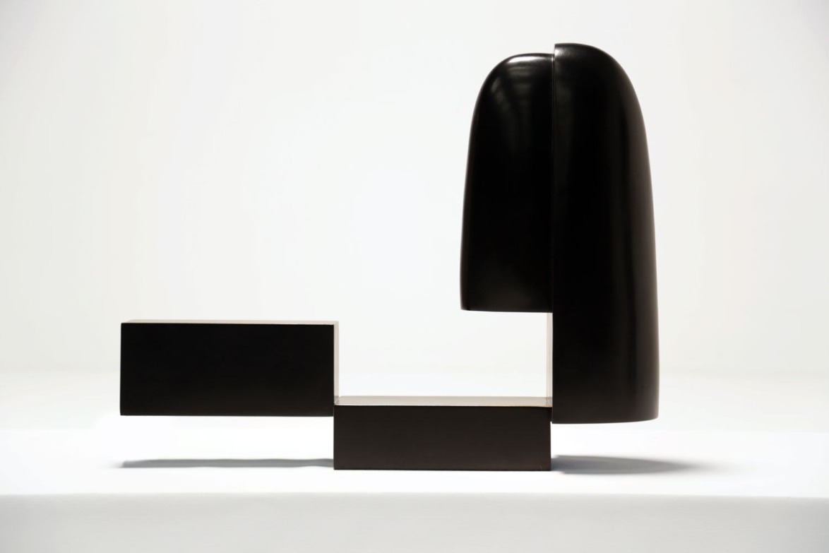 Modern abstract sculpture with geometric black shapes forming an artistic composition against a plain white background.