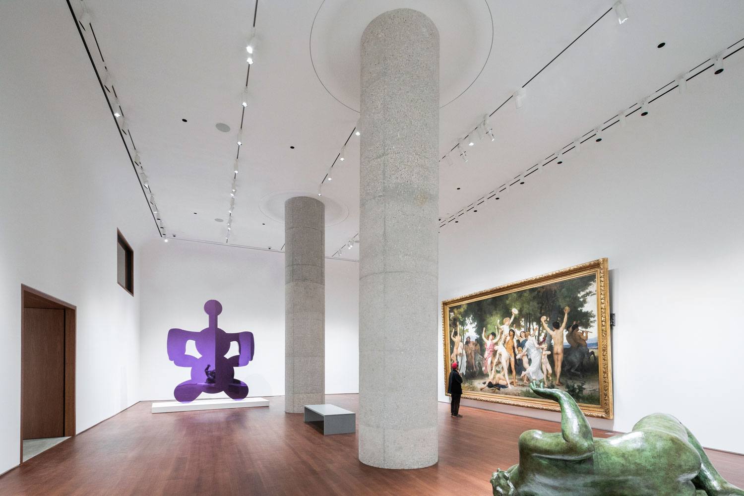 Art museum interior with large painting, abstract sculpture, and stone pillars.