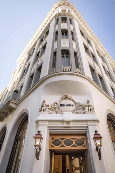 Historic building with ornate architectural details and large windows, featuring decorative sculptures above the entrance.