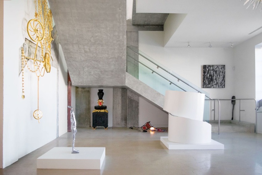 modern art gallery interior with sculptures and abstract art on display near staircase