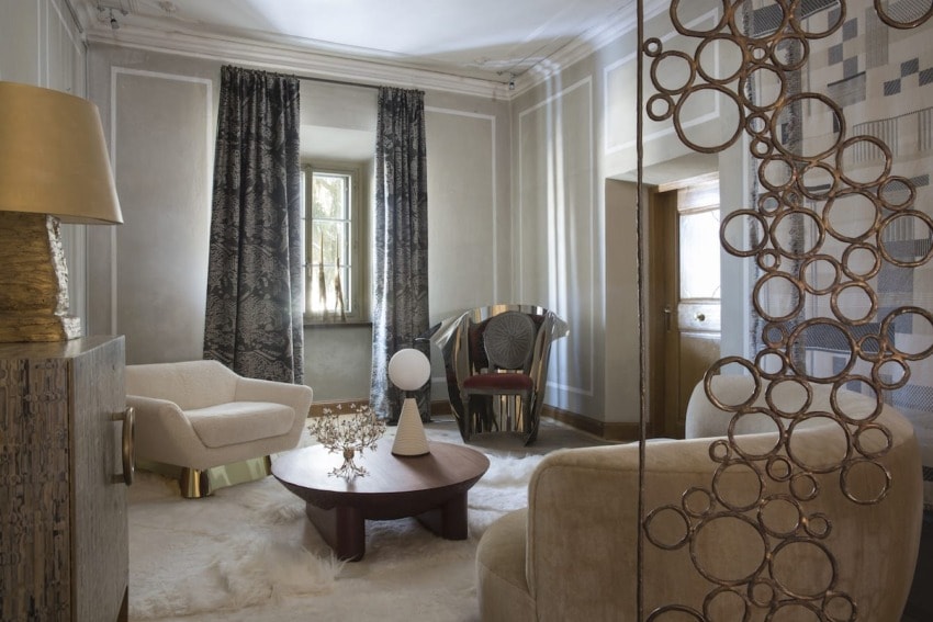 Elegant living room with modern furniture, circular wall decor, patterned curtains, and a central wooden coffee table.