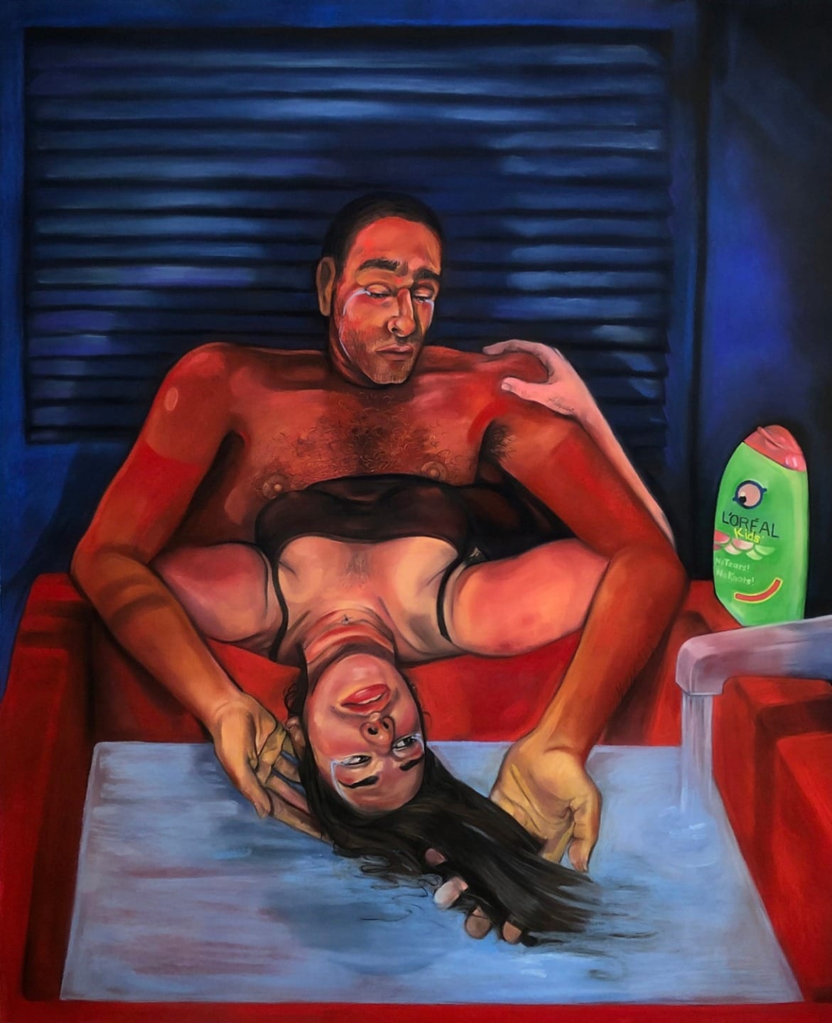 Man washing woman's hair in a dimly lit room with a bottle of shampoo on the counter.