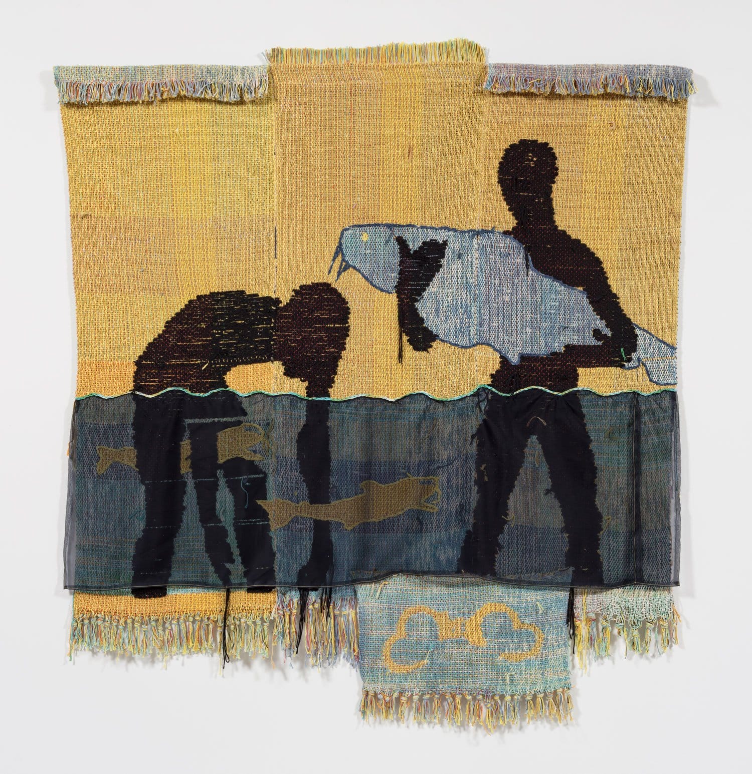 Tapestry art depicting two silhouetted figures and fish against a yellow background, with fringed edges.