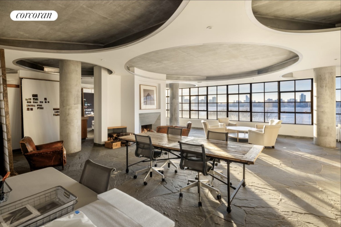 Spacious modern office with large windows, stylish furniture, and natural lighting streaming in.