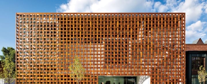 Modern building with a unique geometric facade against a clear blue sky.