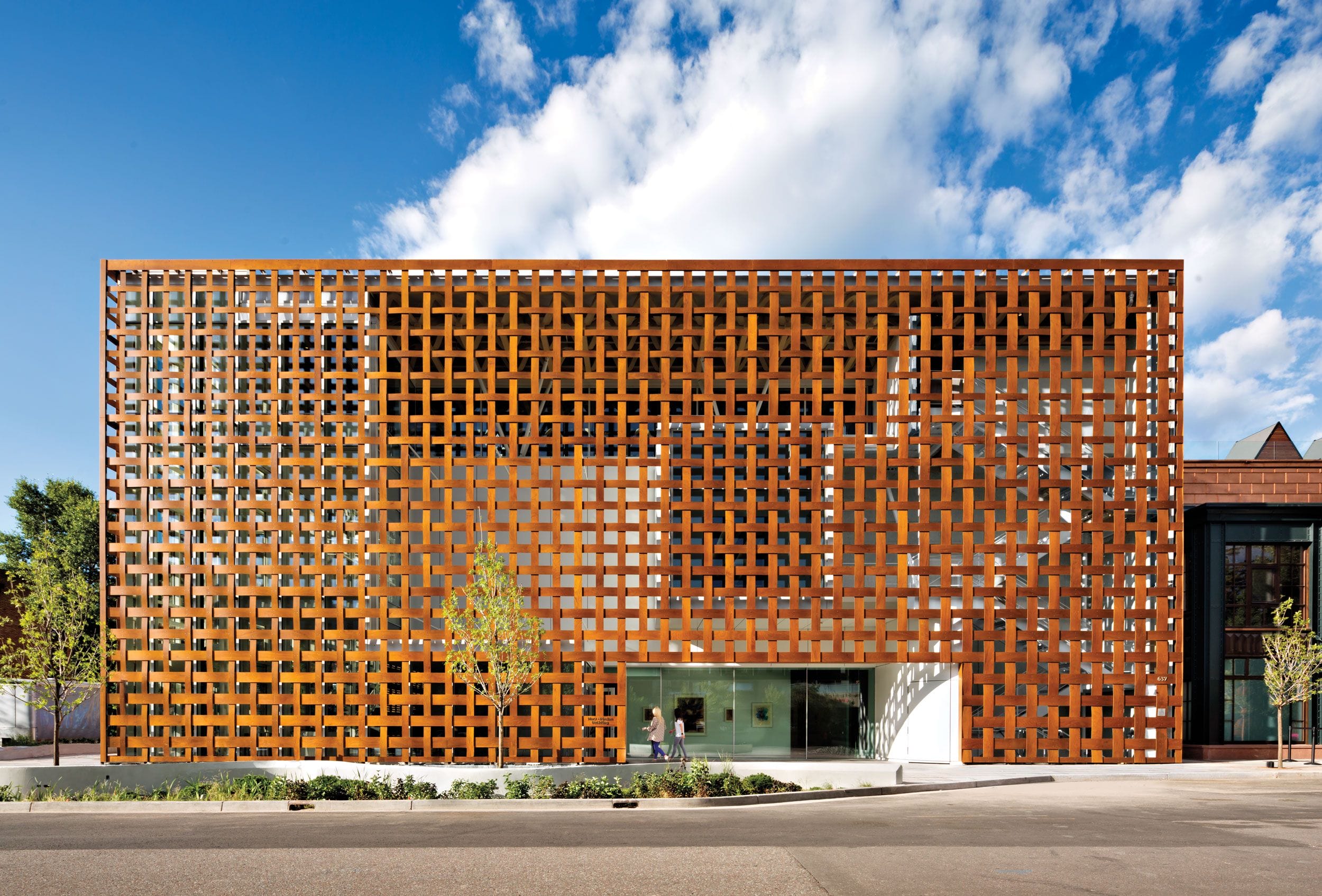 Modern building with a unique geometric facade against a clear blue sky.