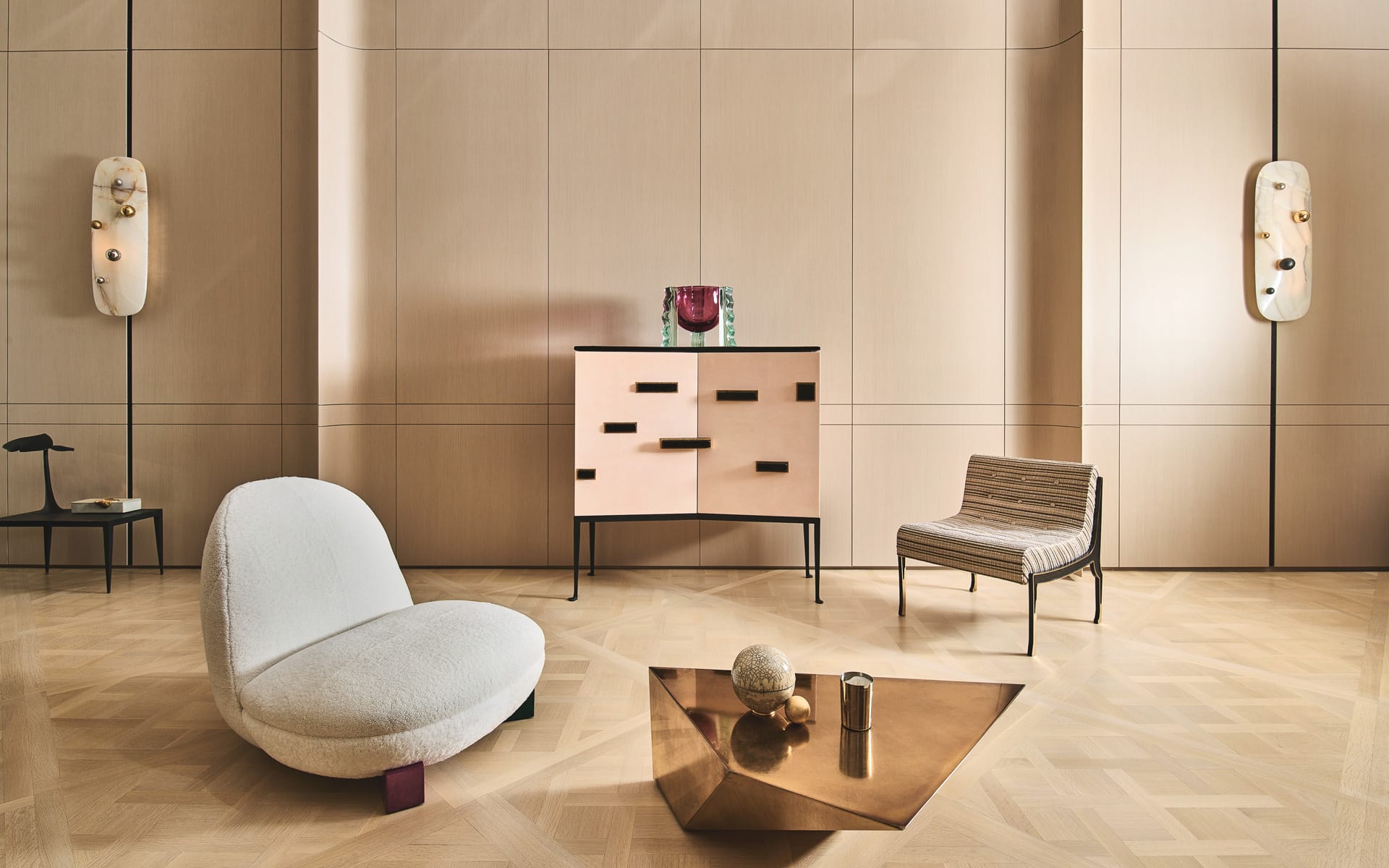 Modern living room with minimalist furniture, including a white chair, striped chair, geometric coffee table, and wall art.