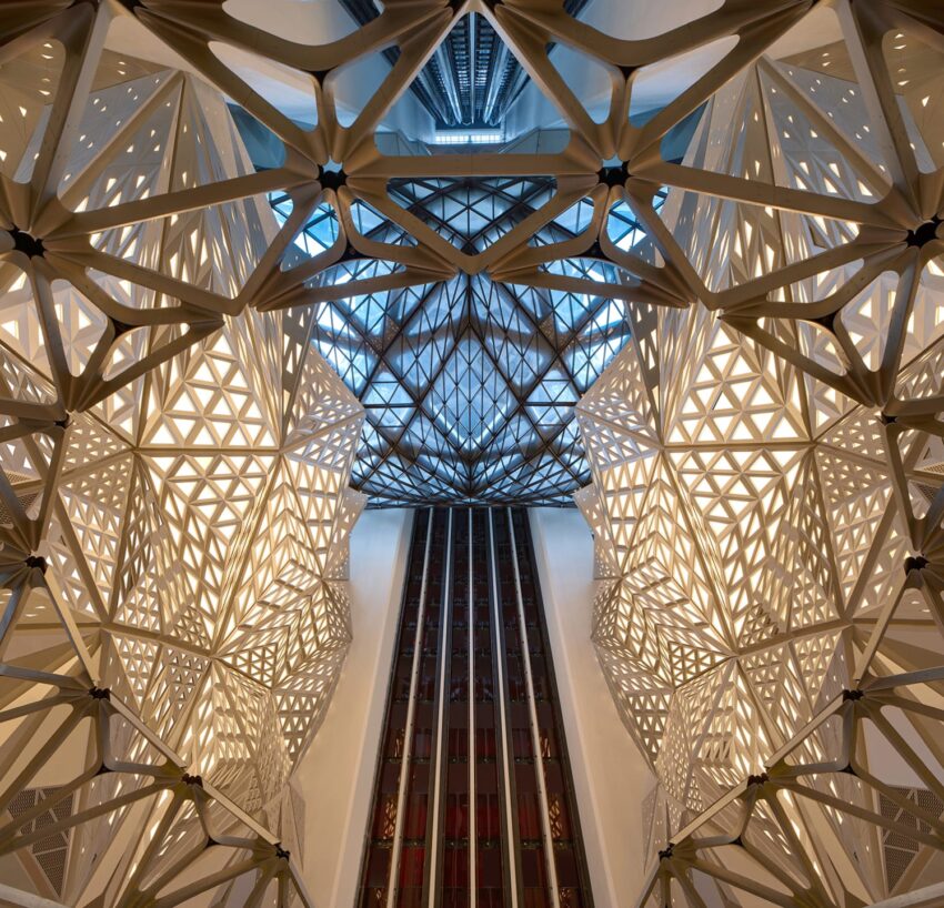 Futuristic geometric architecture with intricate patterns and dramatic lighting viewed from a central interior perspective.