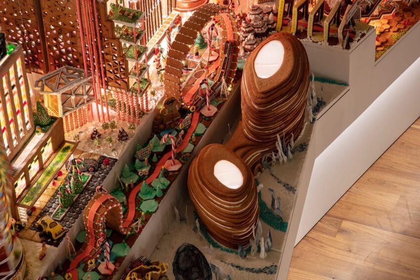 Detailed gingerbread cityscape with architectural structures, roads, and landscapes made entirely of edible materials.