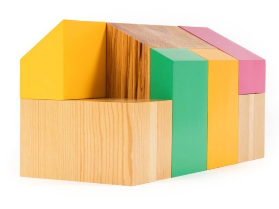 Colorful wooden geometric blocks arranged in an abstract pattern against a white background