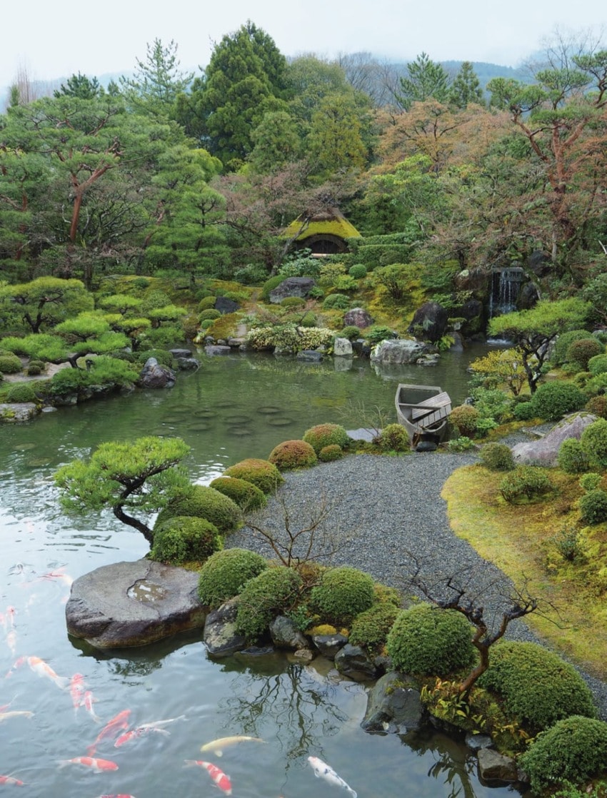 Japanese garden with koi pond, lush greenery, rocks, and traditional wooden boat, creating a serene and tranquil atmosphere.