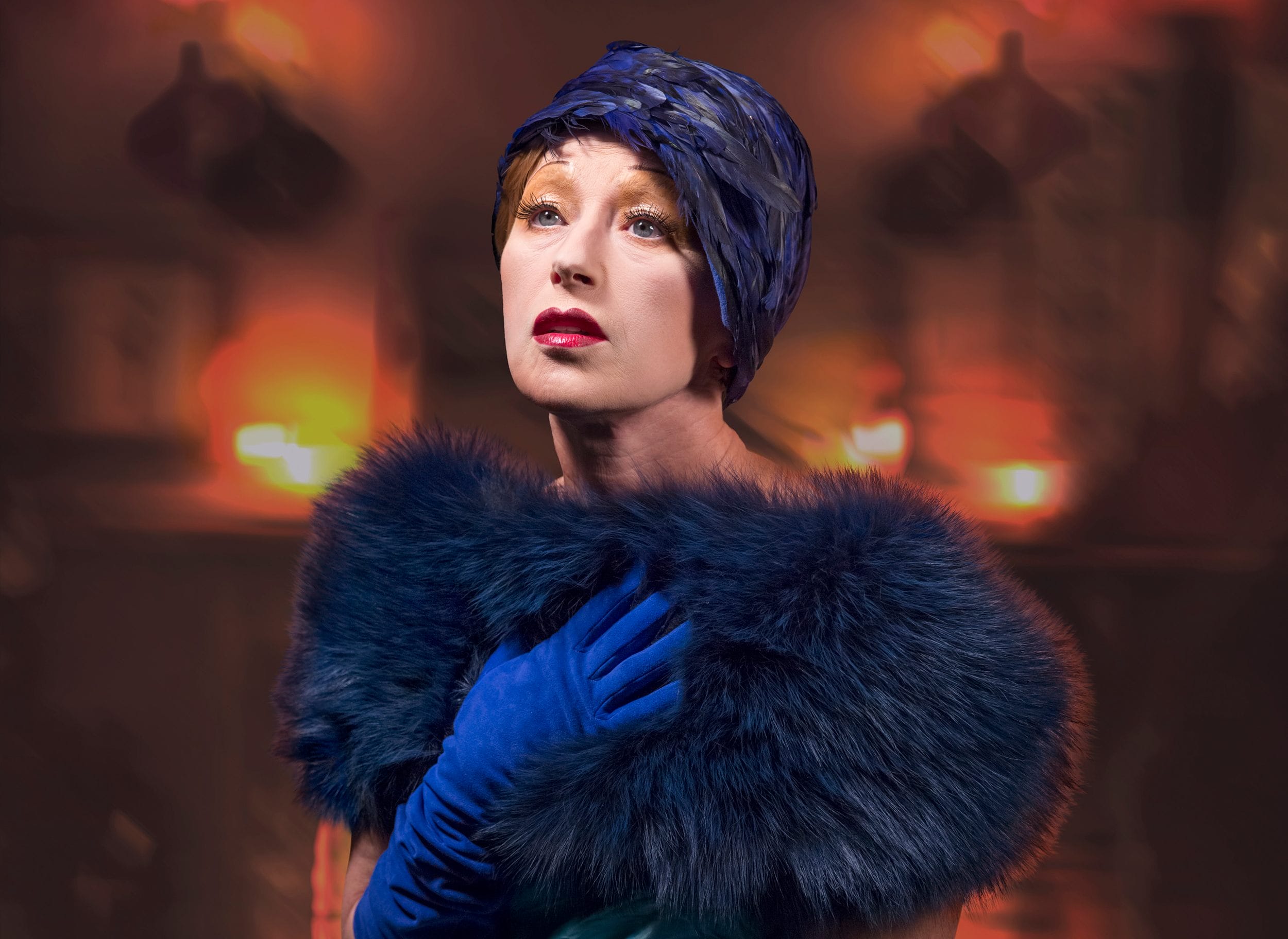 Woman wearing a blue hat and fur shawl in a dramatic, warmly lit setting with a thoughtful expression