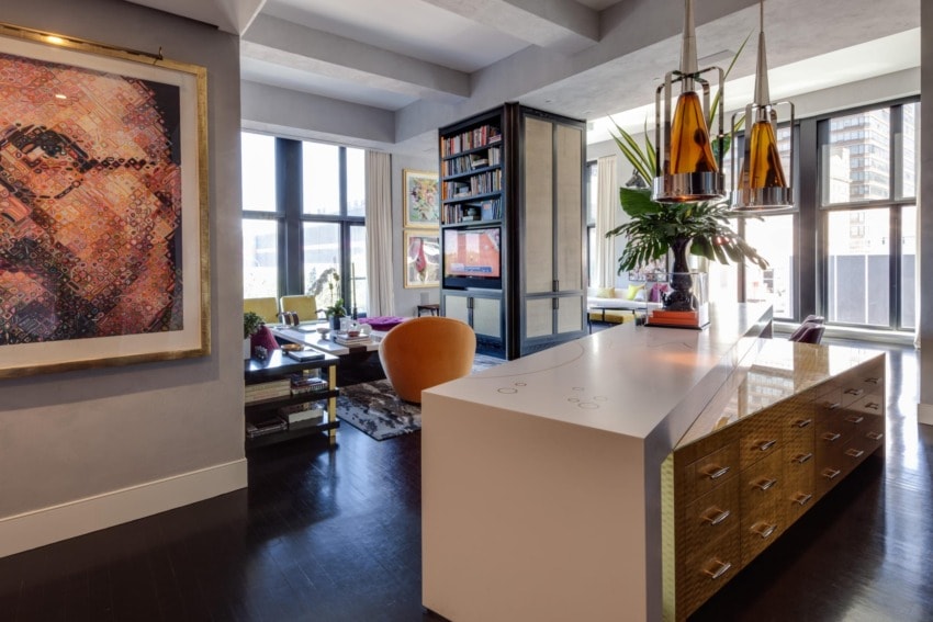 Modern living room with art, large windows, unique lighting, and contemporary furniture in a high-rise apartment.