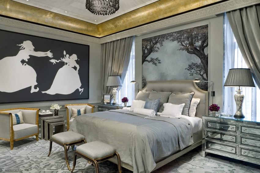 Elegant bedroom with grey tones, modern artwork, luxurious bed, mirrored furniture, and soft, ambient lighting.