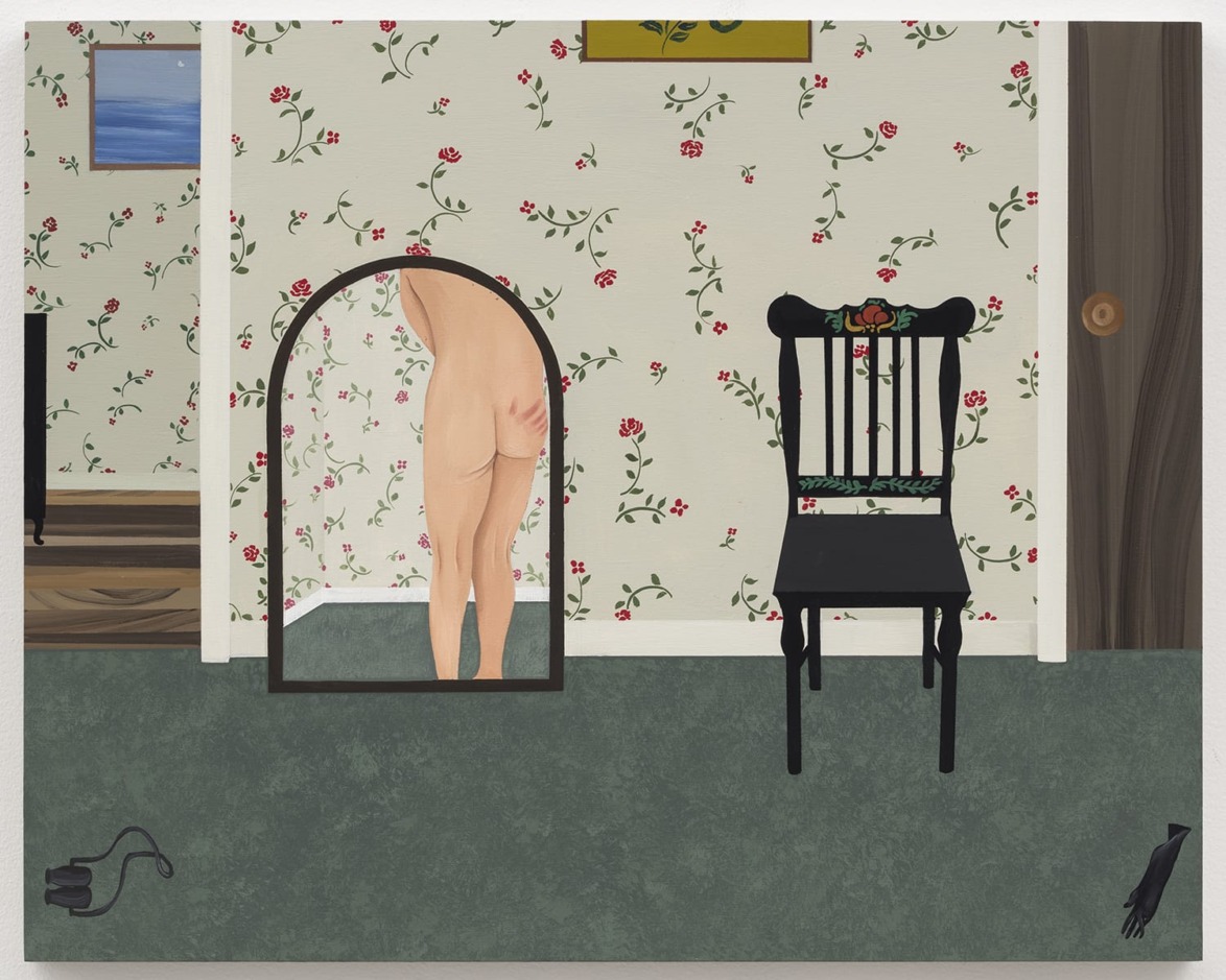 A person standing in front of a mirror with a floral wallpaper background, a black chair, and a small painting on the wall.