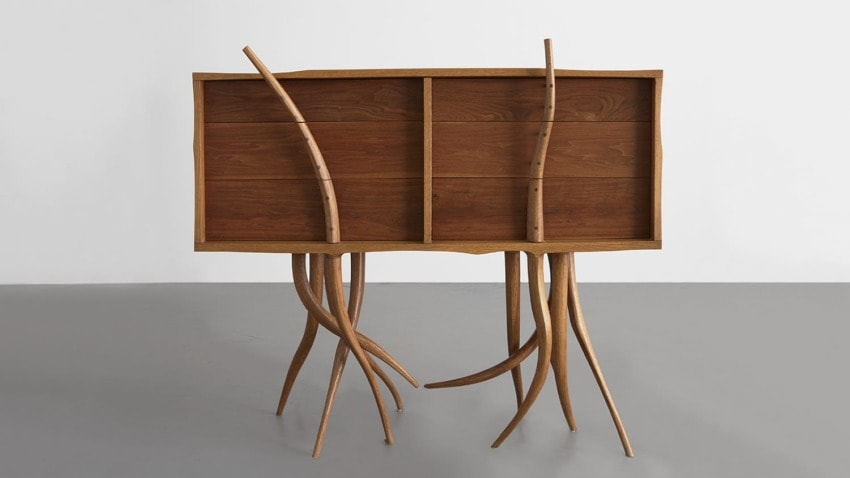 Artistic wooden cabinet with curved, branch-like legs and a smooth, natural finish.