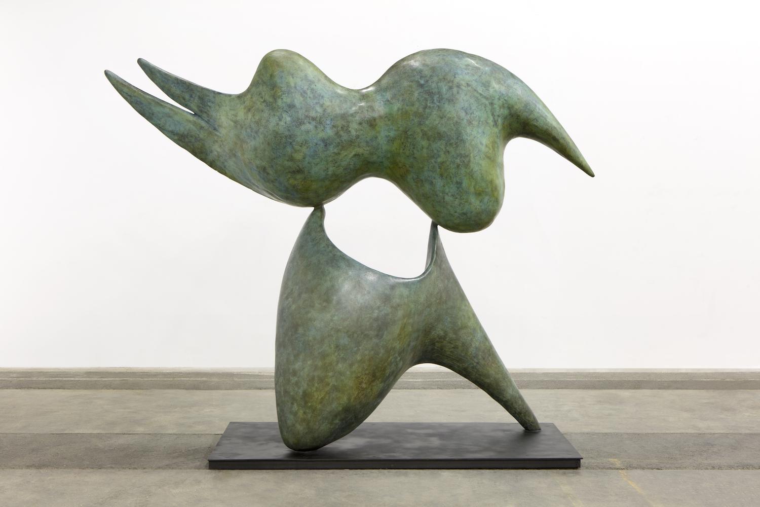 Abstract green bronze sculpture with two curved, pointed forms connected at the center, displayed on a black base.