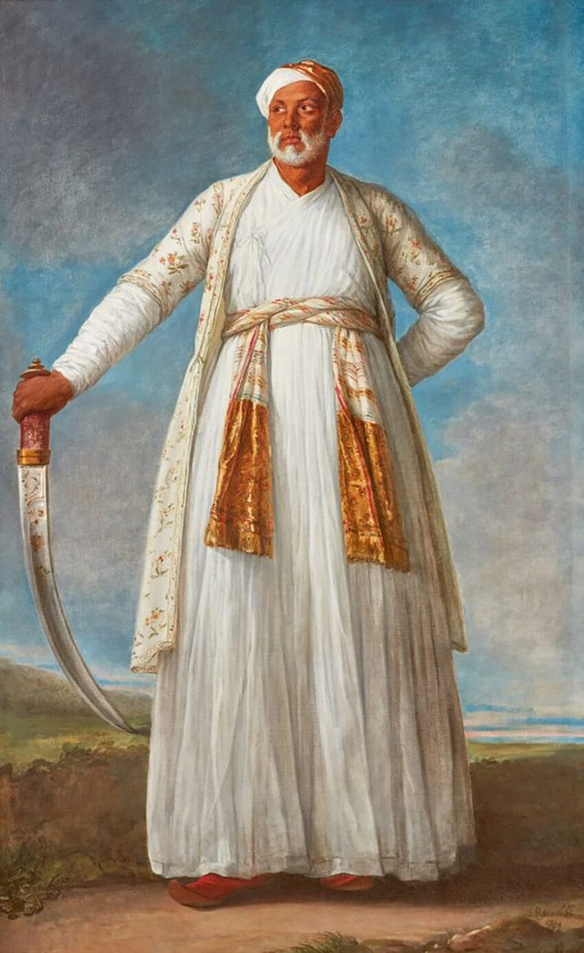 Portrait of a man in traditional attire holding a sword, standing against a landscape backdrop.
