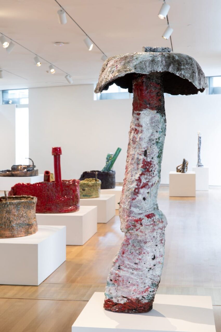Colorful abstract sculptures displayed on white pedestals in a modern art gallery setting.