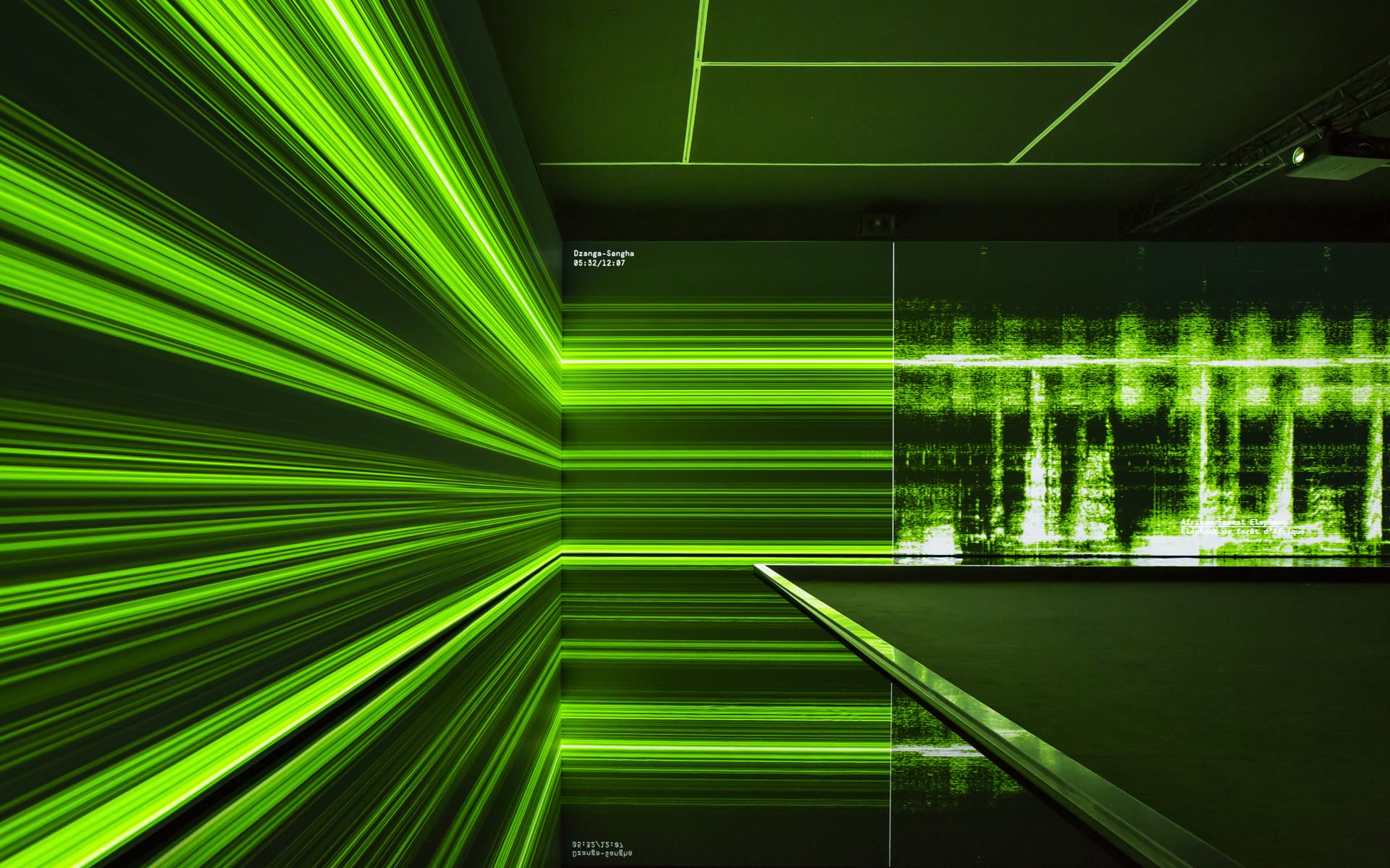 Abstract digital art with green horizontal and vertical lines creating a futuristic, immersive environment in a dark room.