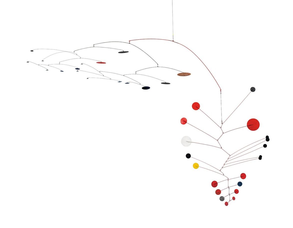 Colorful hanging mobile sculpture with various sized discs and wires, balanced and suspended in the air against a white backdrop.