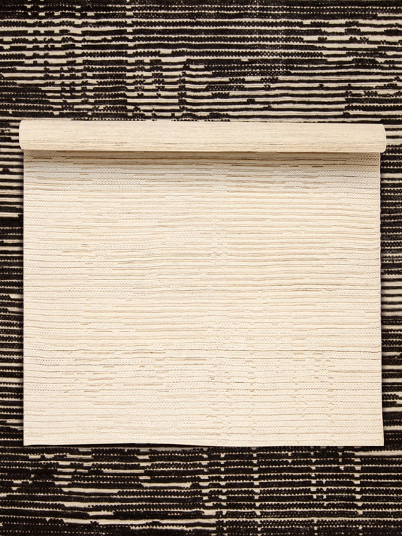 Blank scroll laid flat on a textured black and white background.