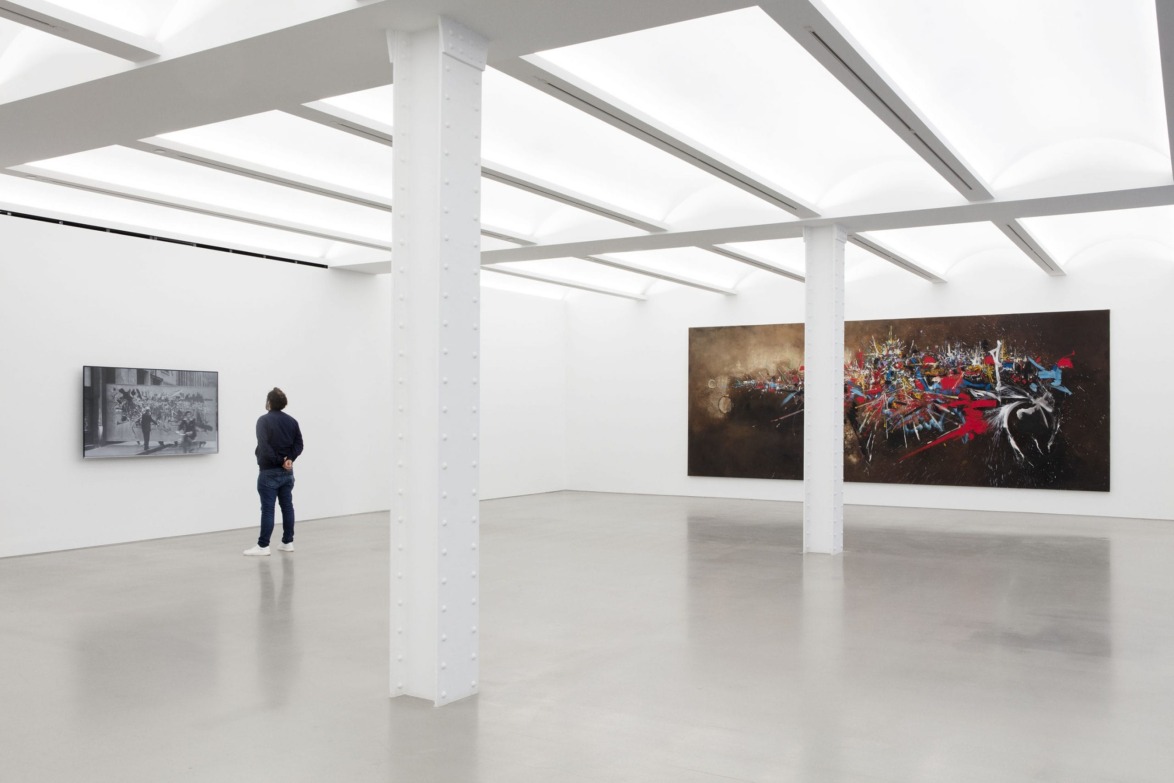 Person viewing abstract art in a modern gallery with large white pillars and minimalist design