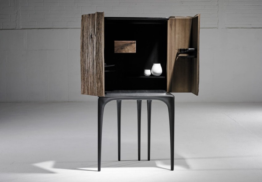 Tall, modern cabinet with open wooden doors revealing minimalist interior on sleek dark legs in a spacious room.