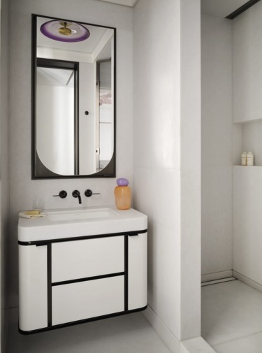 Modern bathroom with a white vanity and a black-framed mirror, featuring a minimalist design and neutral color palette.