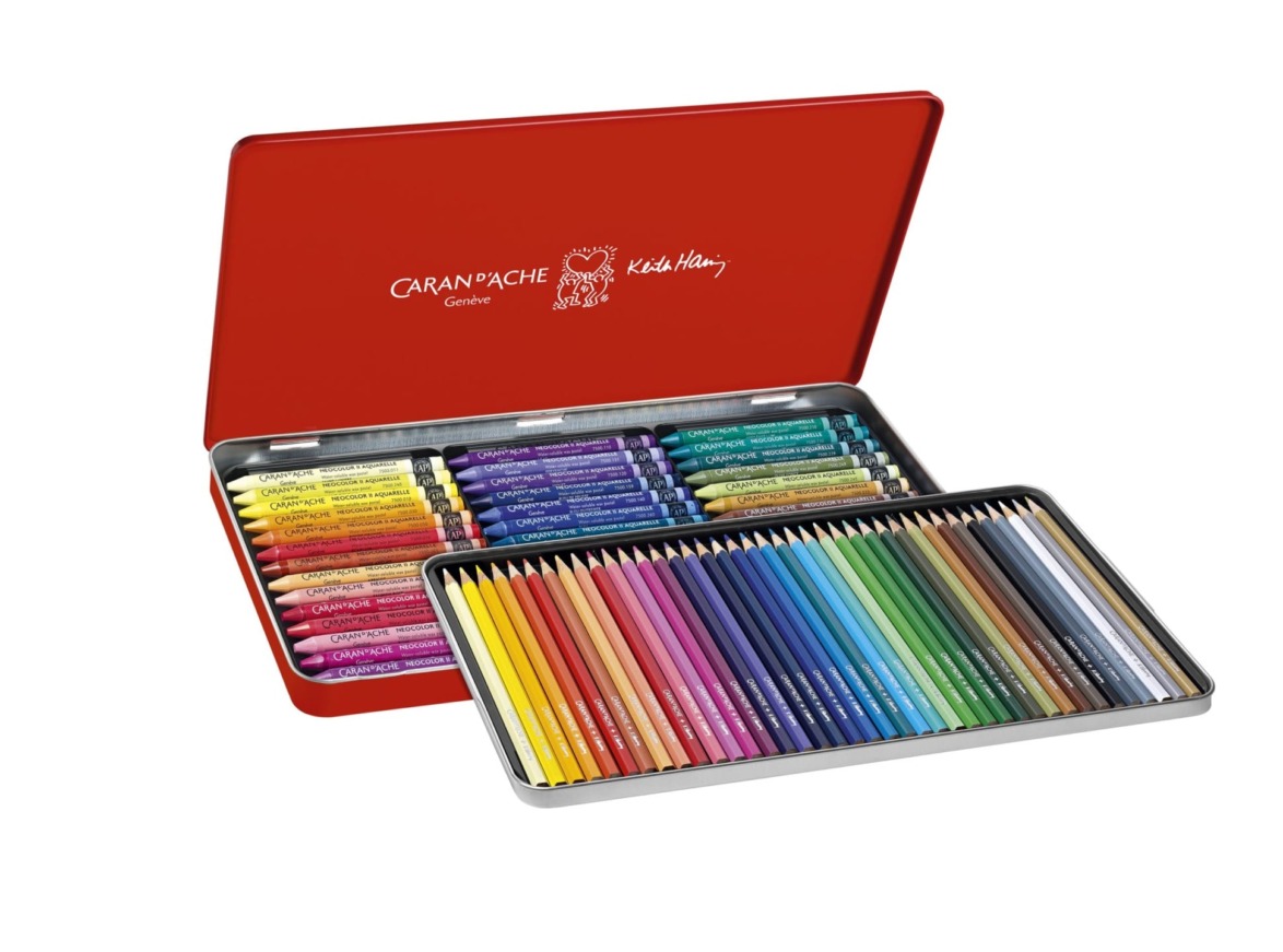open red metal box with assorted colored pencils and crayons arranged neatly inside