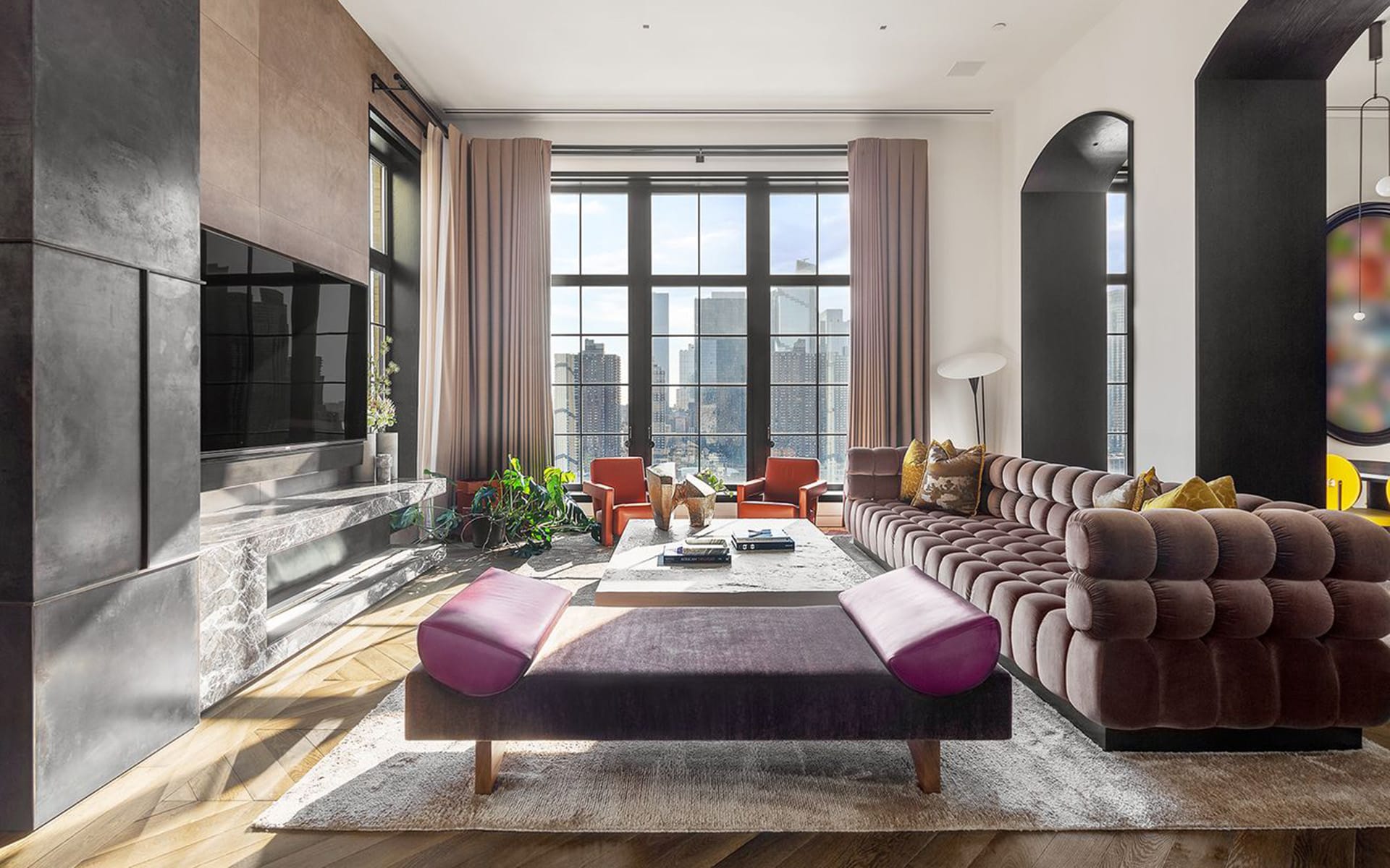 Modern living room with chic furniture, large windows, cityscape view, and contemporary decor.