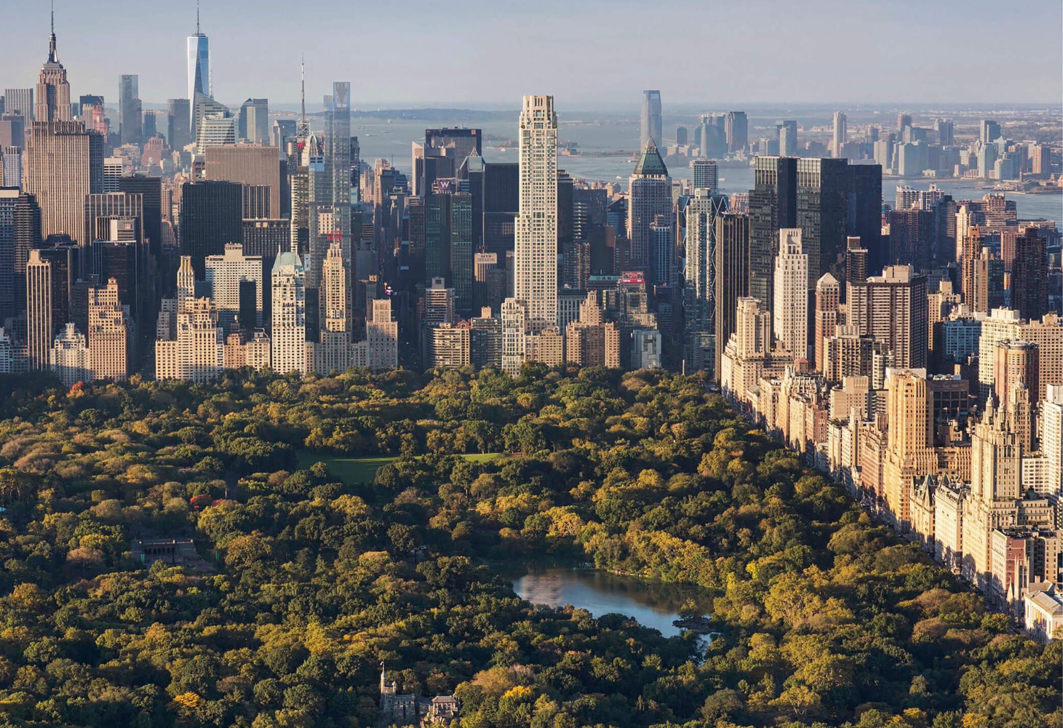 Aerial view of Central Park surrounded by Manhattan skyscrapers, showcasing urban landscape and greenery.