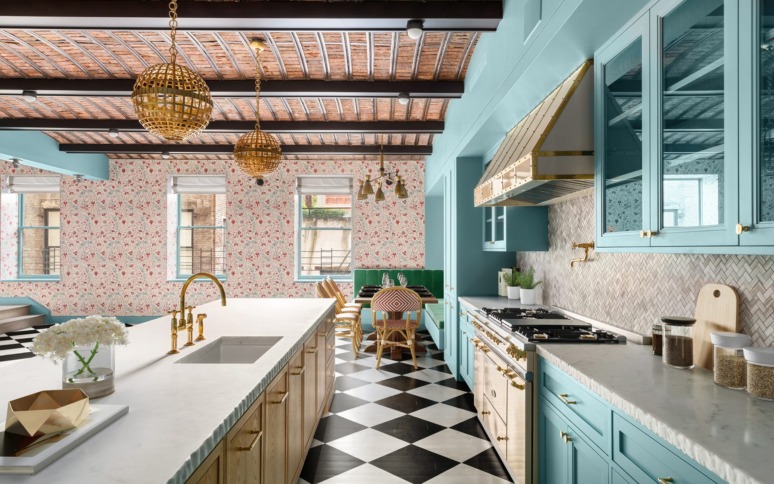 Stylish kitchen with turquoise cabinets, floral wallpaper, black-and-white checkered floor, and gold accents.