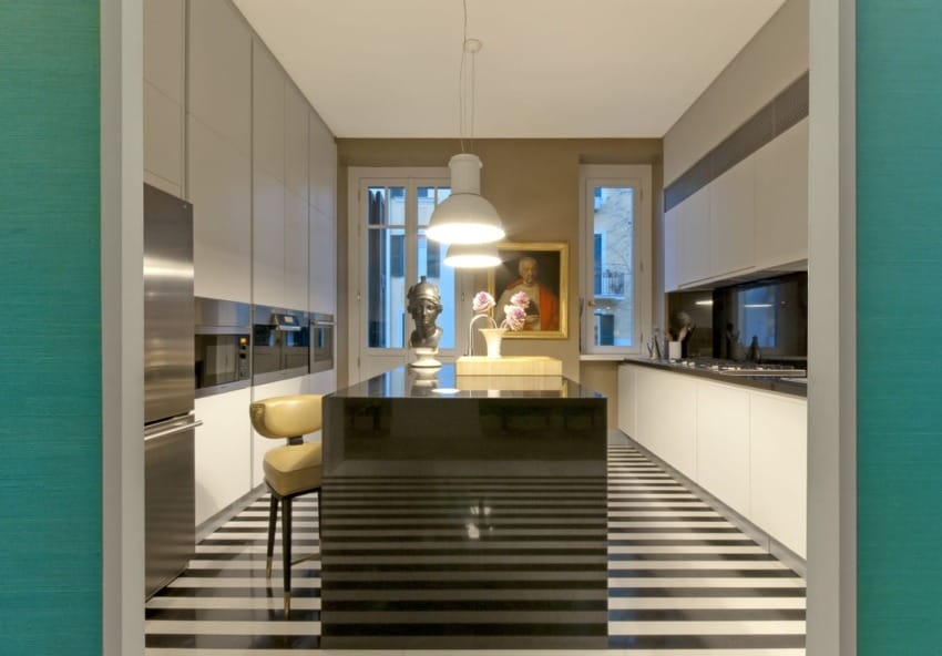 Modern kitchen with striped floor, island countertop, bar stool, pendant lamp, and large framed artwork on the wall.