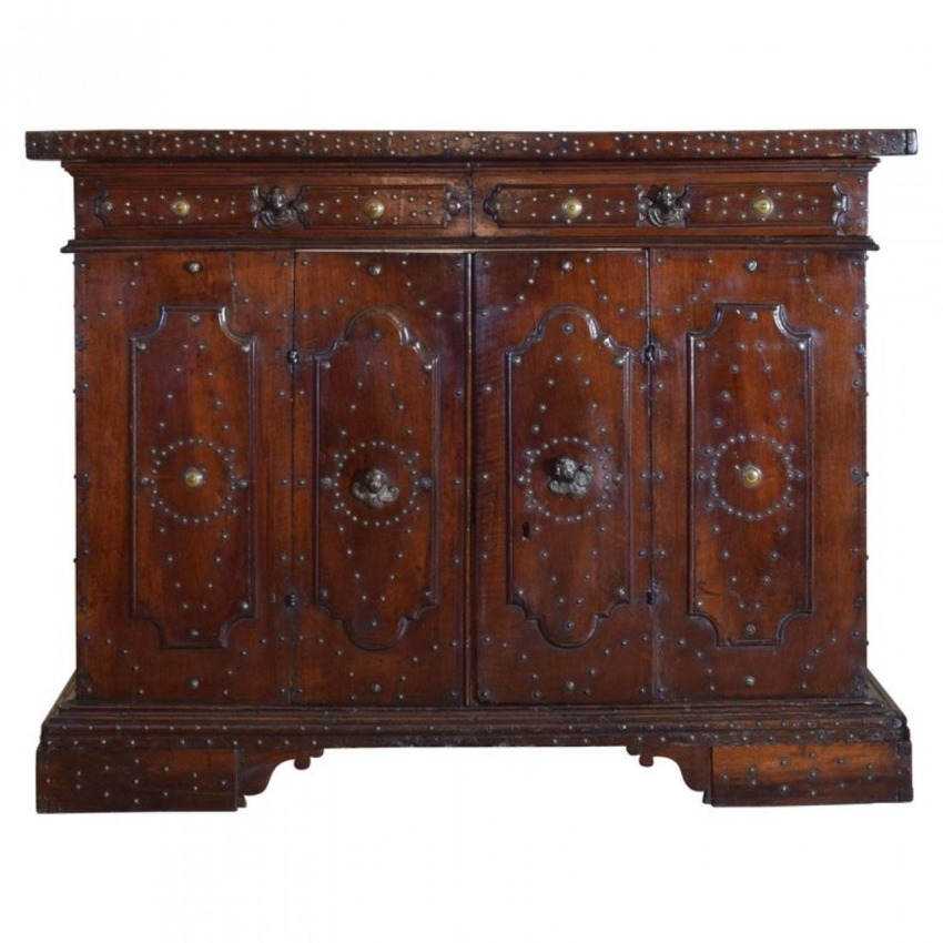 Antique wooden cabinet with ornate metal accents and detailed carvings on doors, featuring a rich, dark finish.