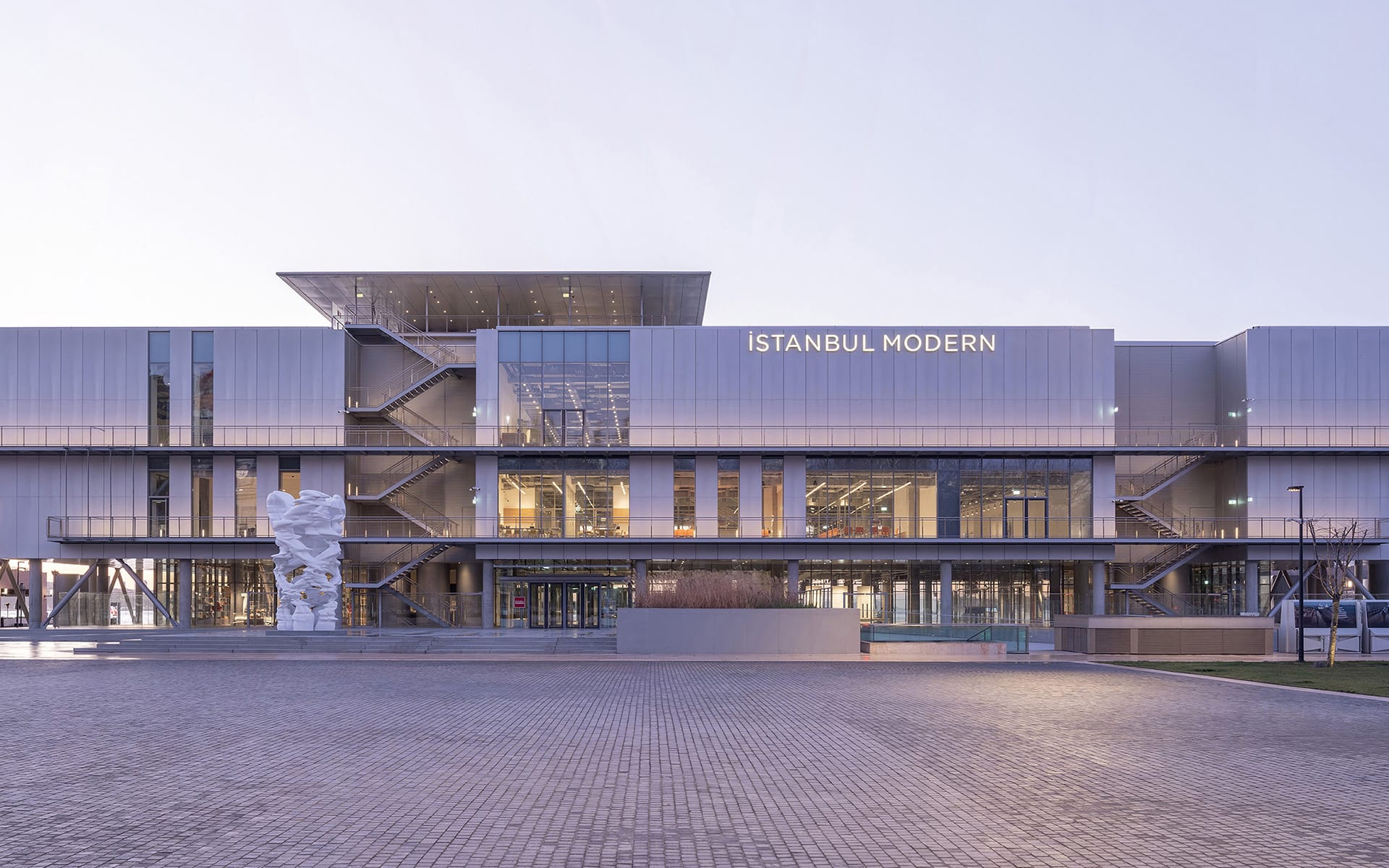 Exterior view of Istanbul Modern Museum with a large sculpture in front, showcasing contemporary architectural design.