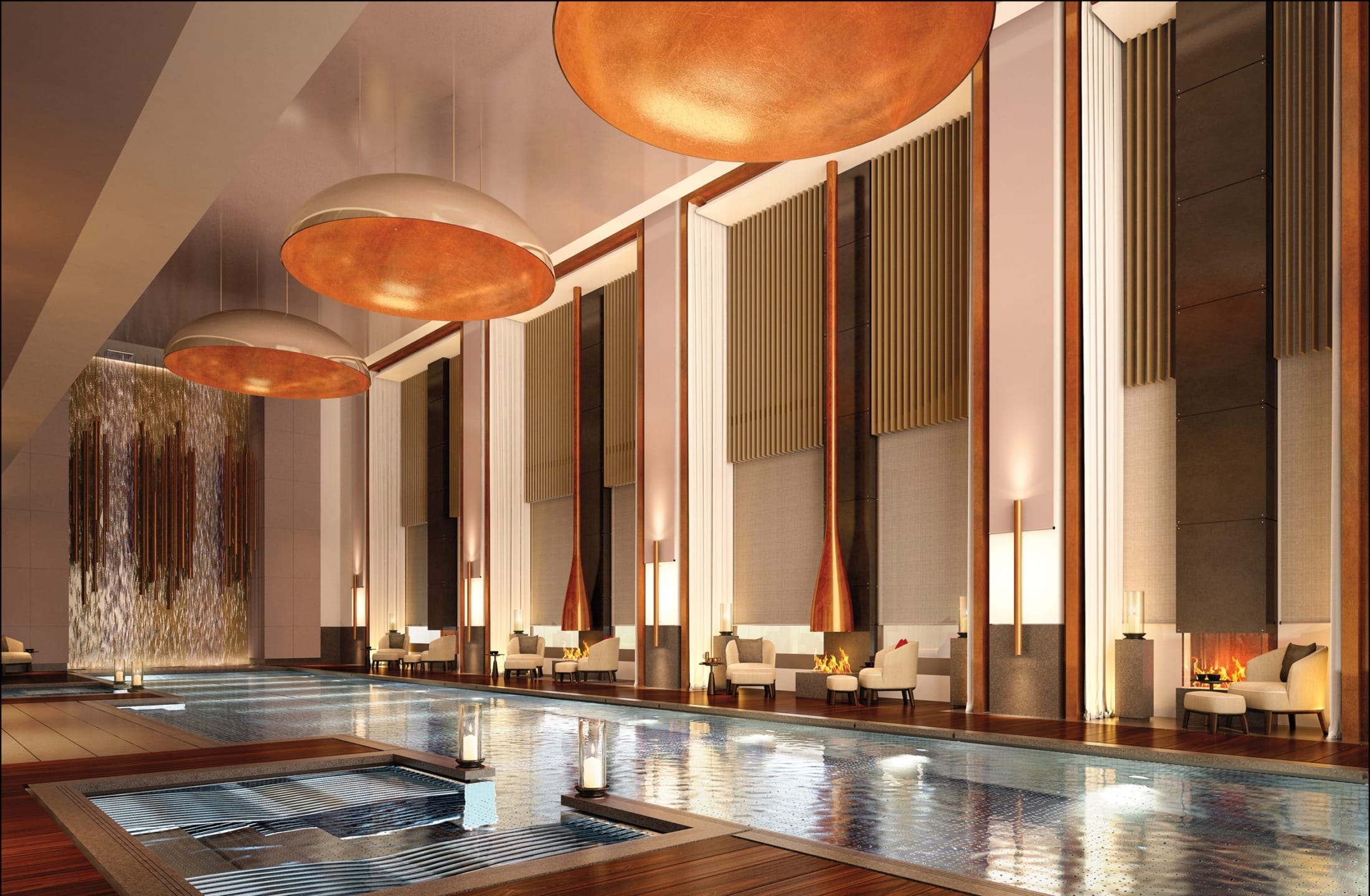 Luxury indoor swimming pool with elegant lounge chairs, modern decor, large pendant lights, and a cascading water feature.
