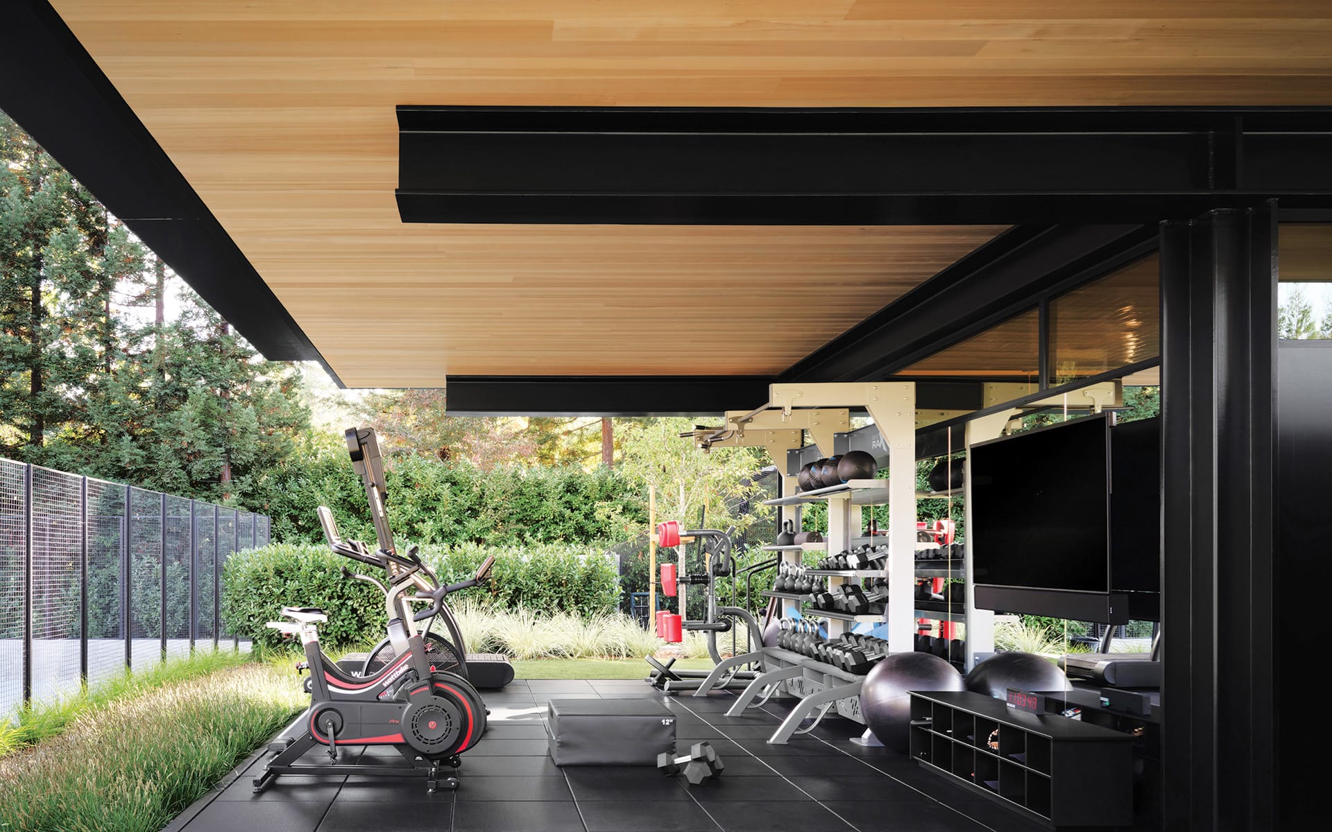 For a California client who enjoys outdoor recreation, Olson Kundig orchestrated this open-air fitness area, which features hemlock boards on the ceiling and Ecore Everlast flooring.