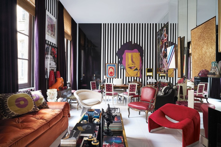 Eclectic living room with bold colors, striped walls, and modern artwork.