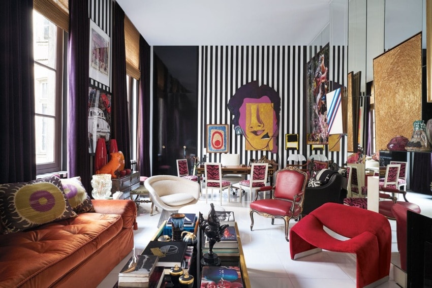 Eclectic living room with bold colors, striped walls, and modern artwork.