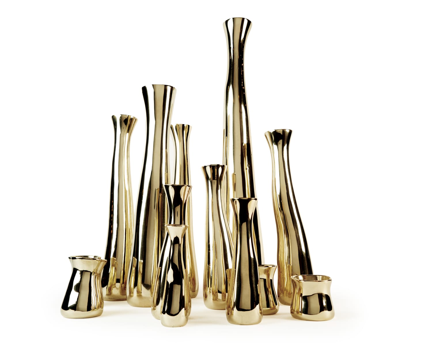 Tall, slender gold vases of varying heights arranged in a group against a plain white background.