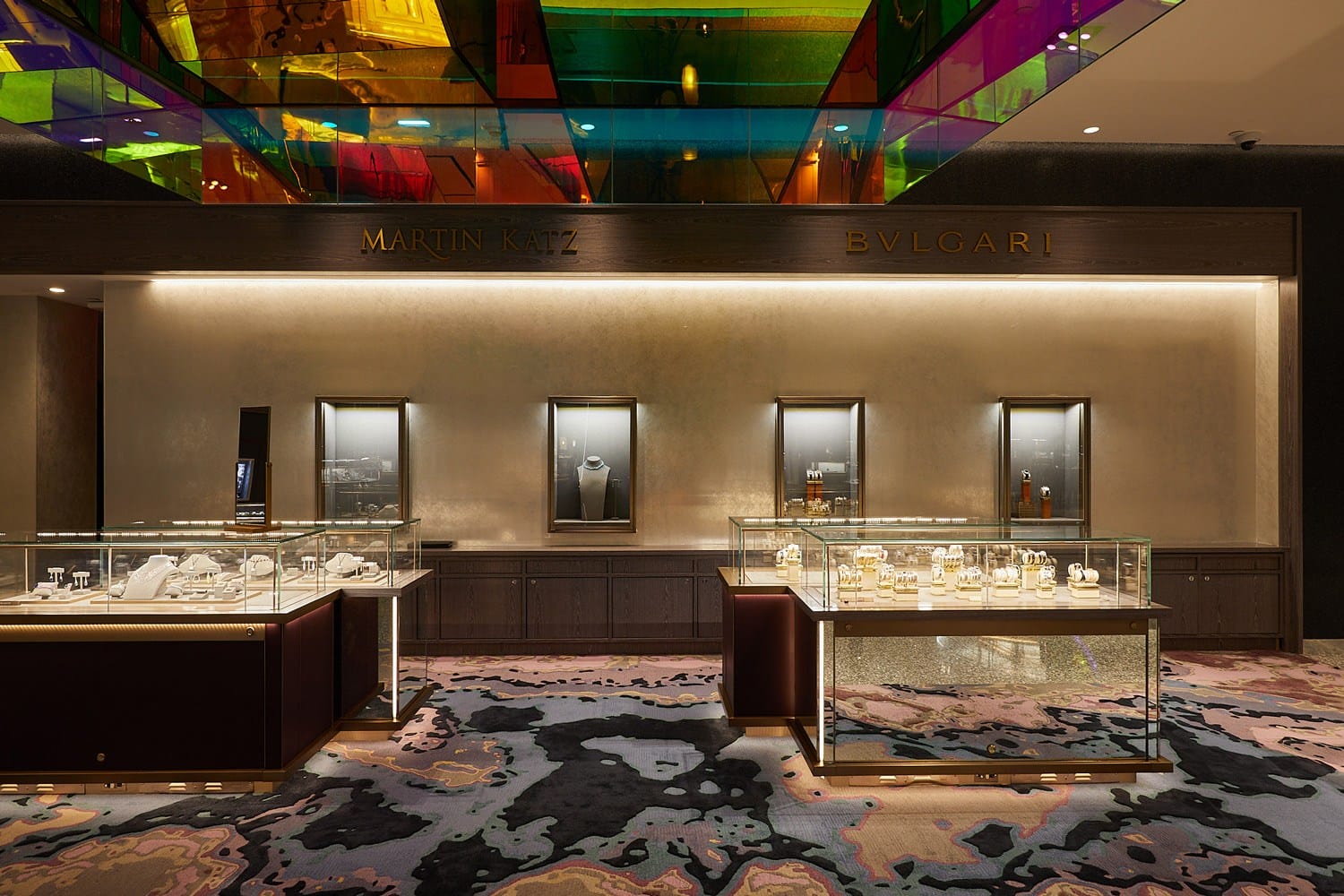 Luxury jewelry display at a high-end boutique with colorful ceiling reflections and elegant showcases.