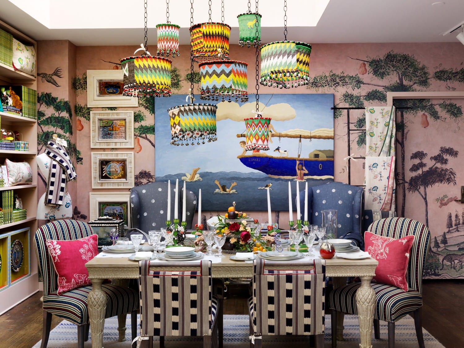 Eclectic dining room with vibrant pendant lights, patterned chairs, artistic walls, and a colorful centerpiece on the table.