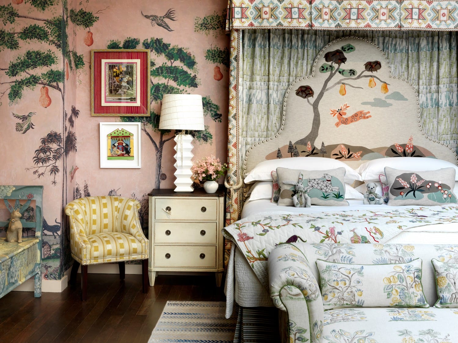 Eclectic bedroom with floral wallpaper, patterned bedspread, framed art, and a yellow striped chair.